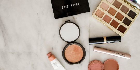 photo of assorted makeup products on gray surface
